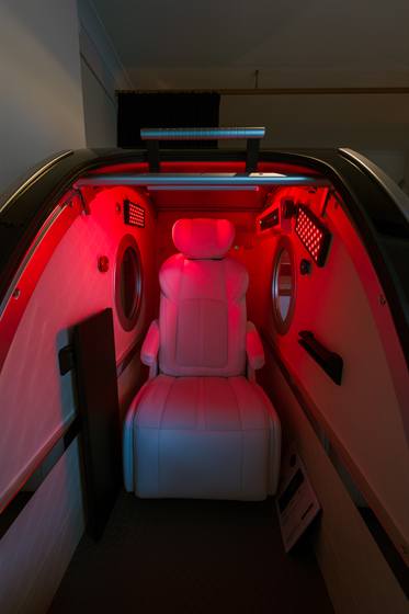 Inside the hyperbaric chamber: the white seat under red light