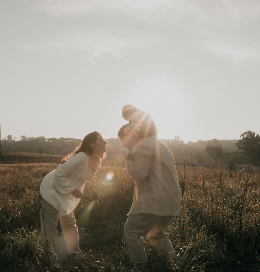 A couple in a field, backlit by low sun