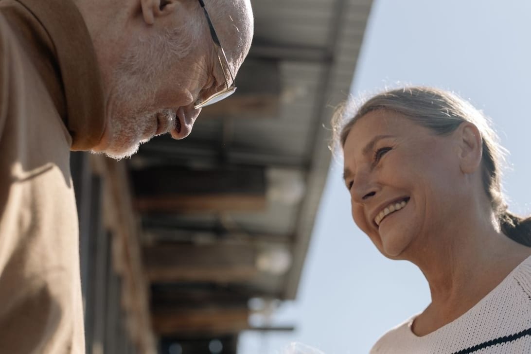 An older couple laughing together in afternoon light
