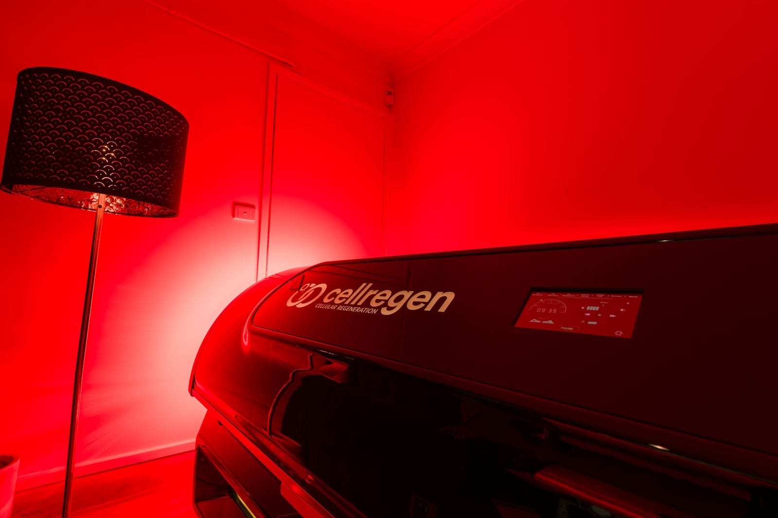 The CellRegen red light bed glowing in the treatment room